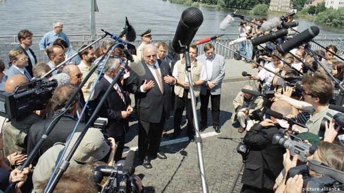 Chancellor Helmut Kohl speaking to journalists by the Oder river